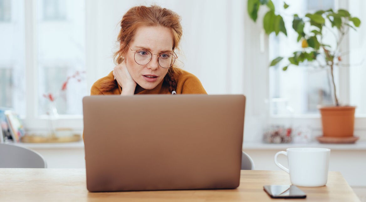Frau schaut etwas ratlos auf ihren Laptop