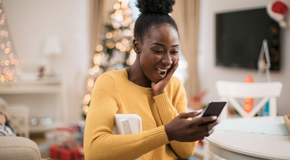 Frau führt Videoanruf mit dem Smartphone und ist ganz entzückt