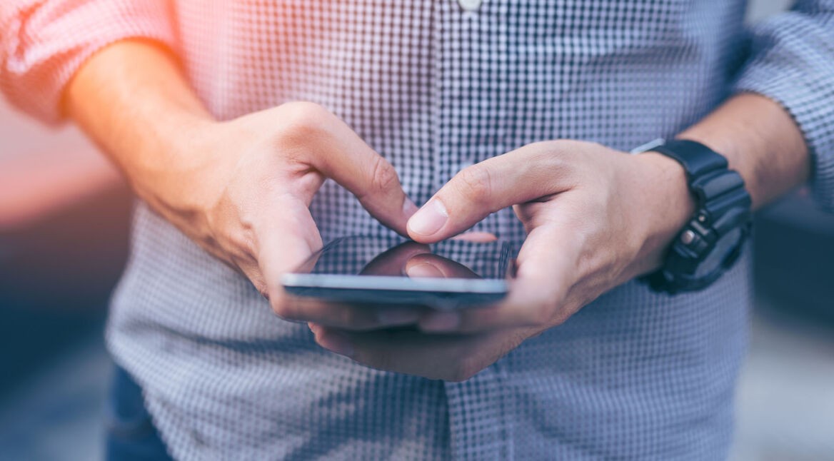 Mann nutzt auf seinem Smartphone CalyxOS