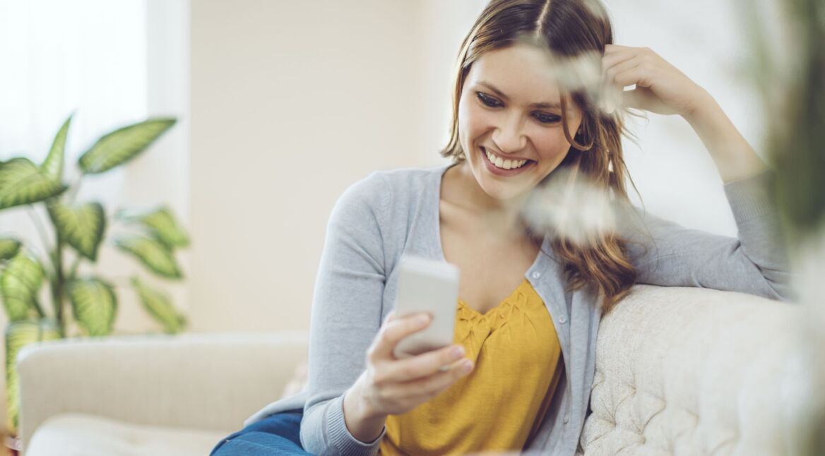 Frau nutzt WhatsApp am Handy.