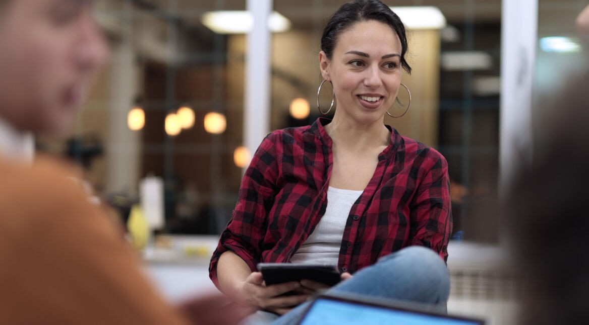 Frau hält Tablet in einem Meeting
