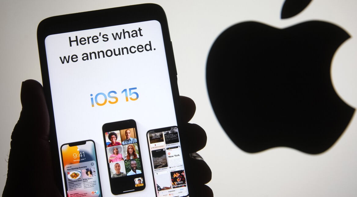 Hand hält iPhone mit iOS 15 vor Apple-Logo
