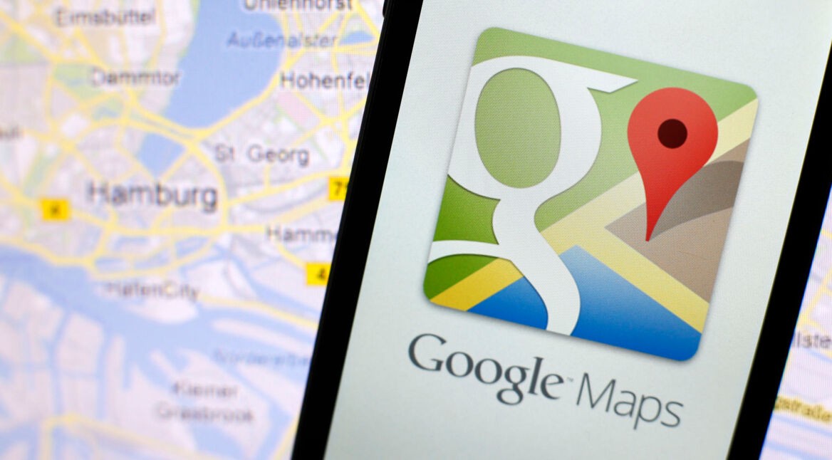 Google-Maps-App auf einem Smartphone neben einer Karte