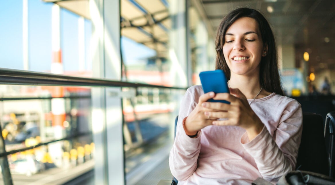 Frau nutzt ihr Smartphone unterwegs