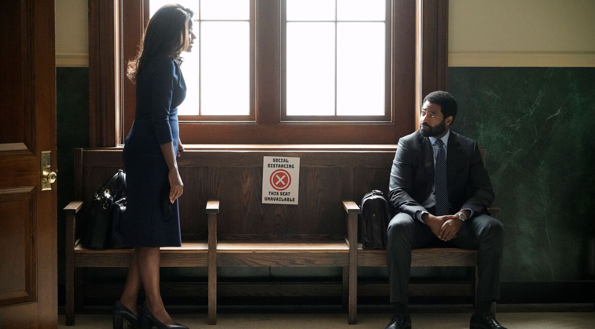 Ein Mann und eine Frau unterhalten sich auf dem Gang eines Gerichts