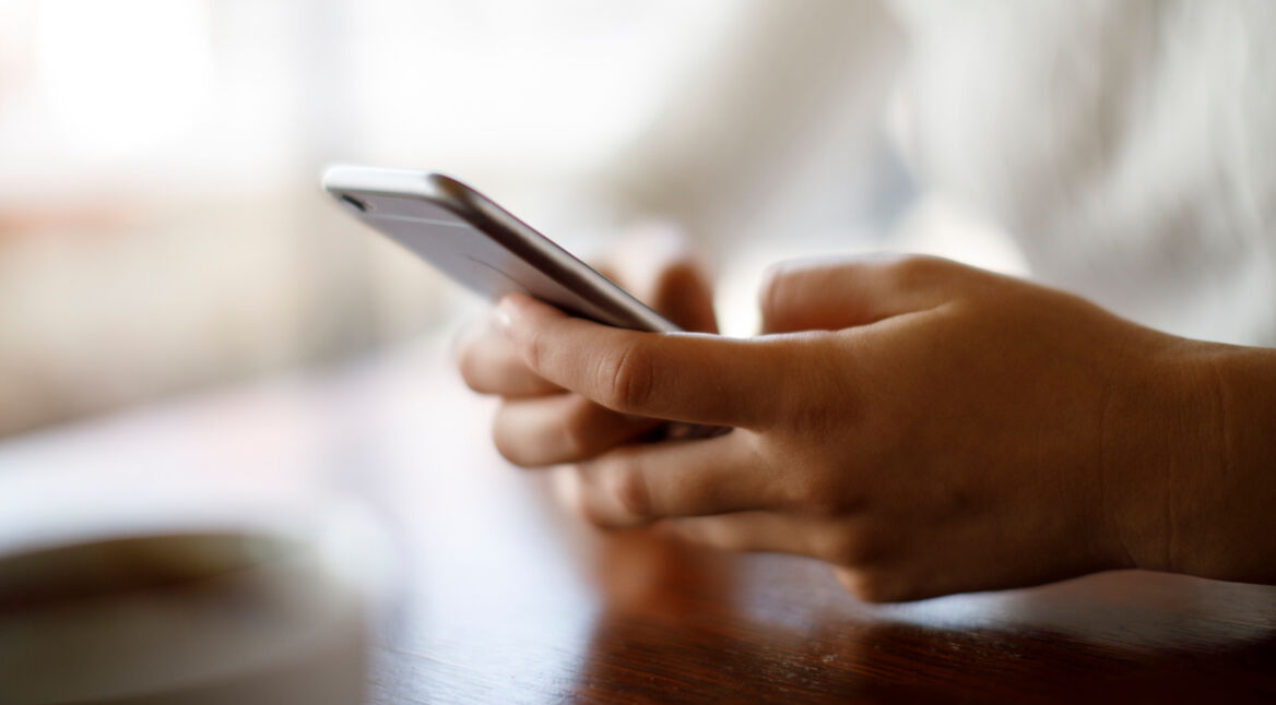 Frau hält iPhone in der Hand.