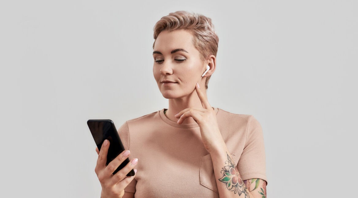 Frau mit Smartphone und AirPods-Kopfhörern