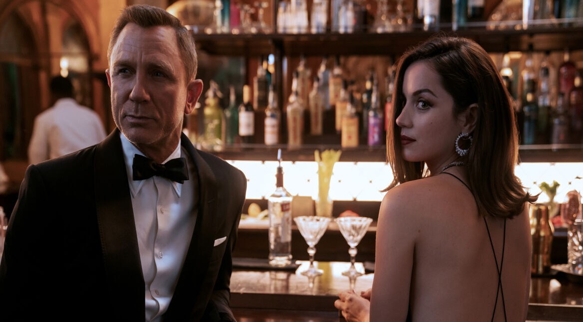 James Bond (Daniel Craig) und die Agentin Paloma (Ana de Armas) sitzen an einer Bar.