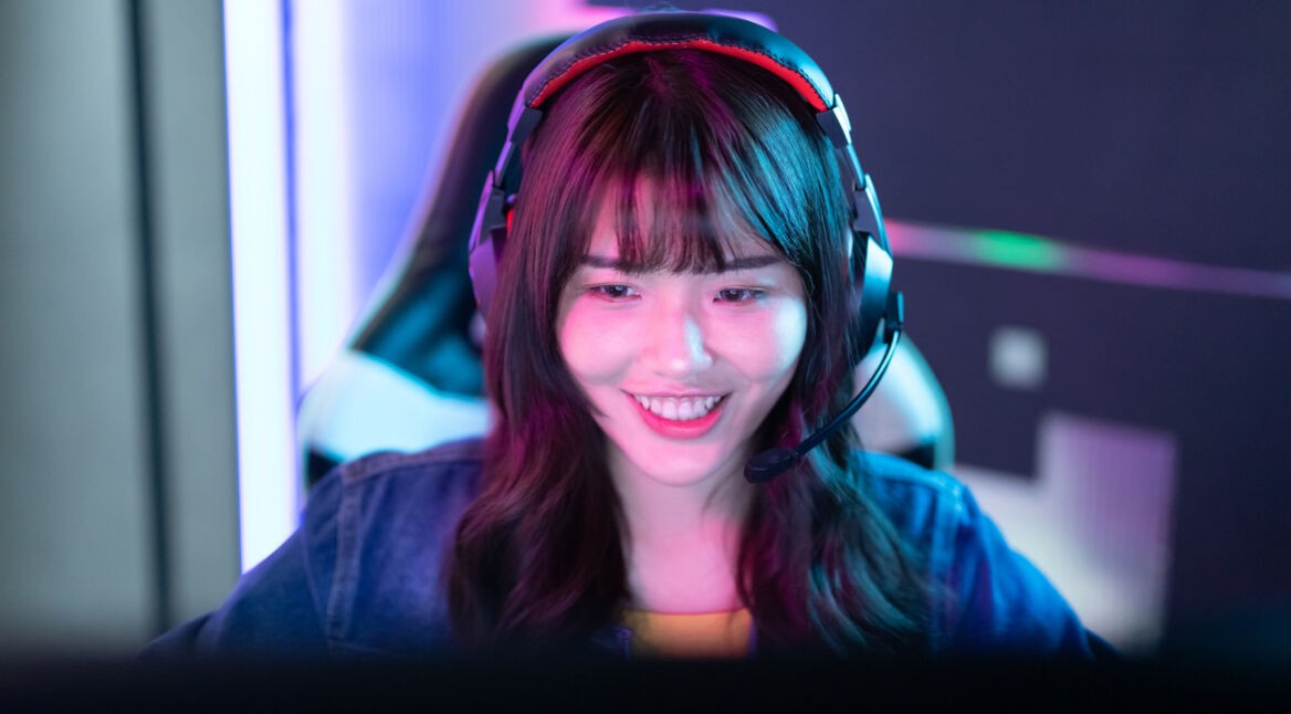 Frau mit Headset sitzt am Computer