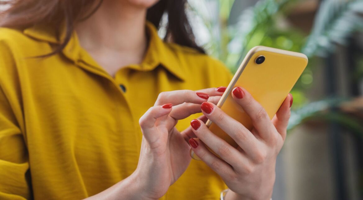 Frau chattet an ihrem Handy.