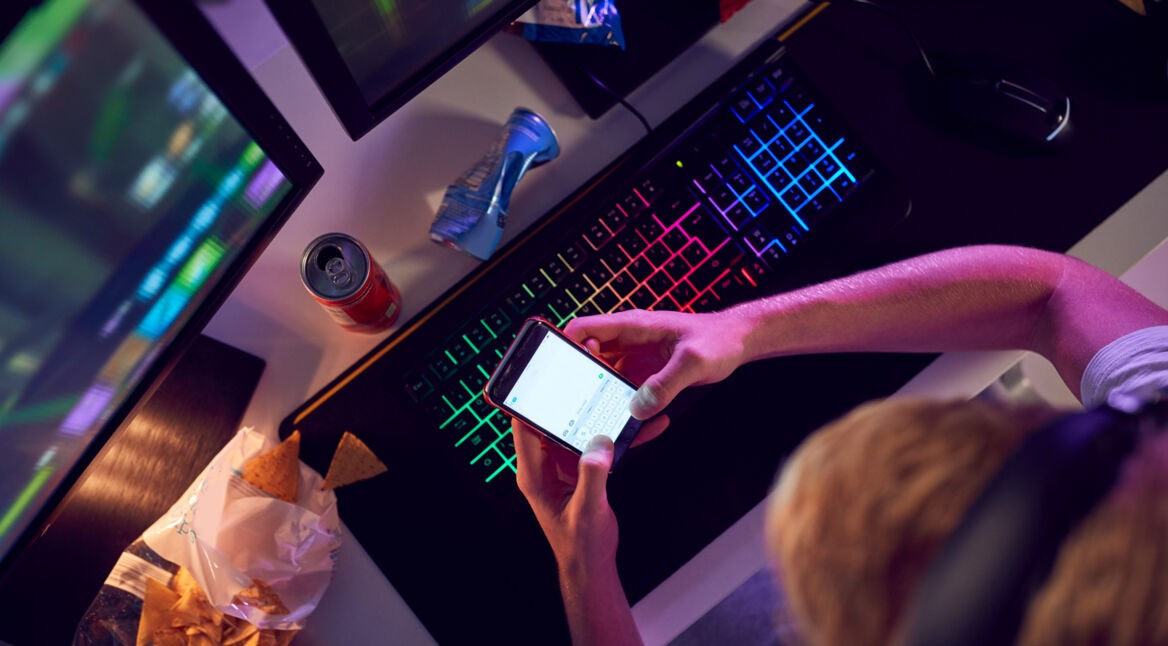 Gamer, der auf seinem Smartphone chattet.