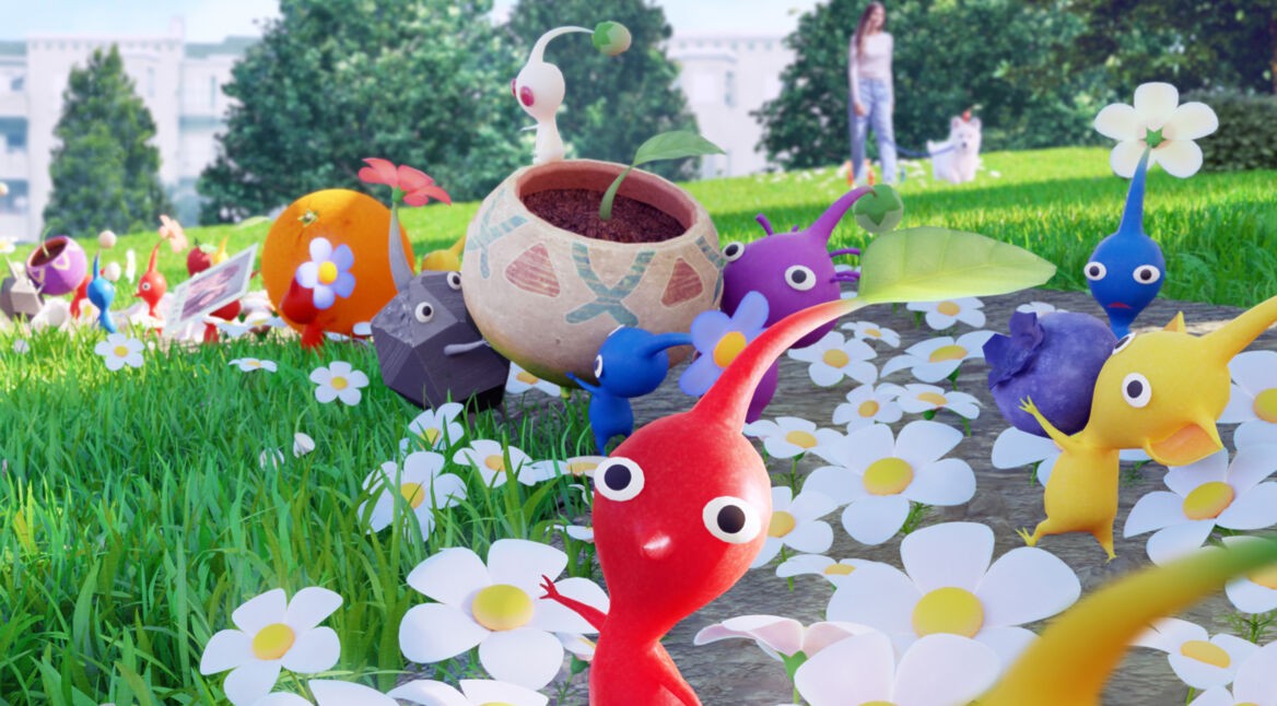 Die kleinen Pflanzenwesen namens Pikmin sind auf einer Wiese unterwegs und lassen Blumen wachsen.