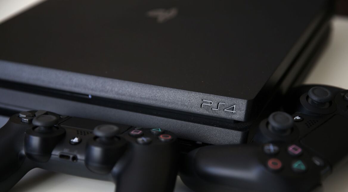 Die PS4 und zwei Controller liegen auf einem Tisch.