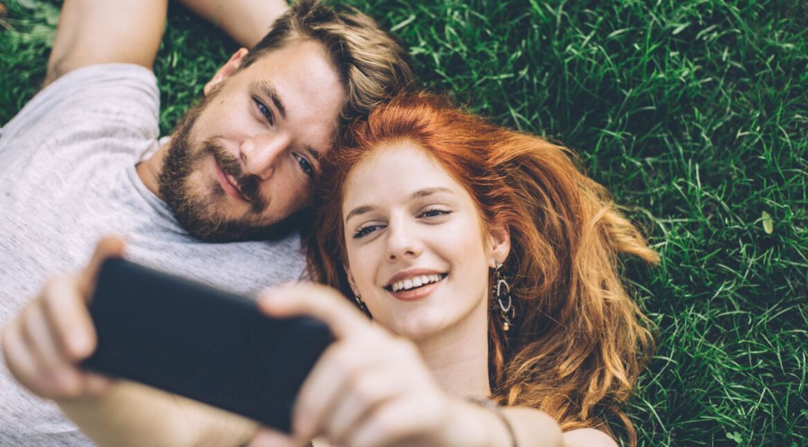 Paar nimmt Selfies mit dem Handy auf.