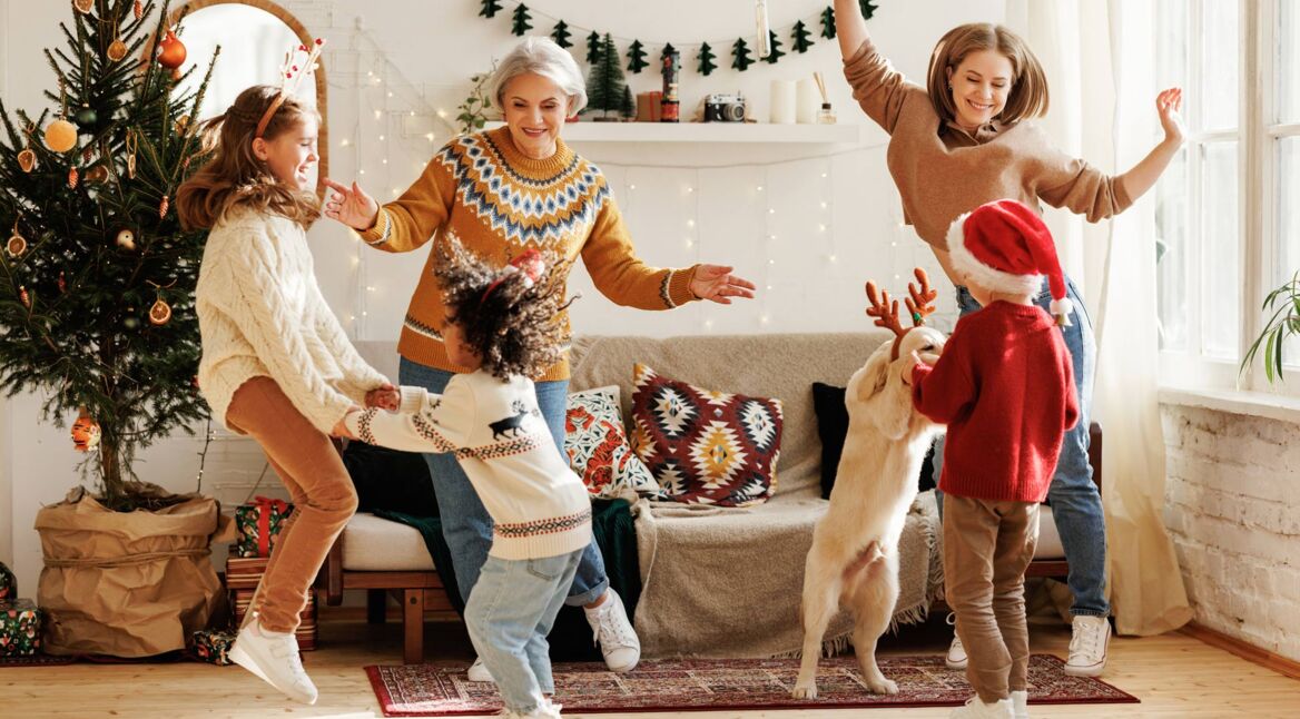 eine Familie aus unterschiedlichen Generationen mit einem Golden Retriever, die alle tanzen