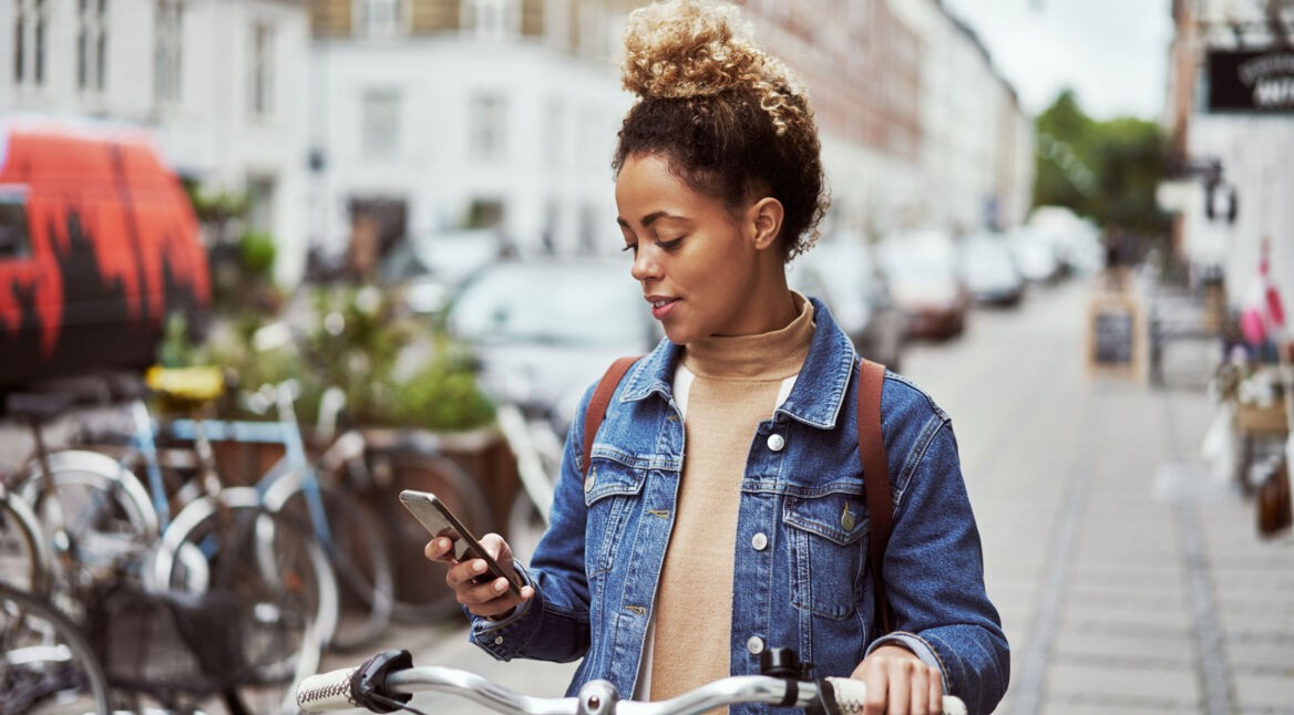 Junge Frau mit Fahrrad nutzt Kalender-Apps