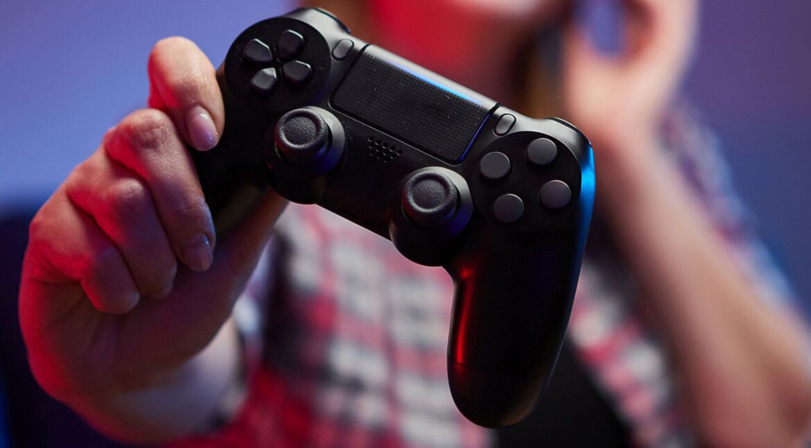 Frau hält PS4-Controller in der Hand.