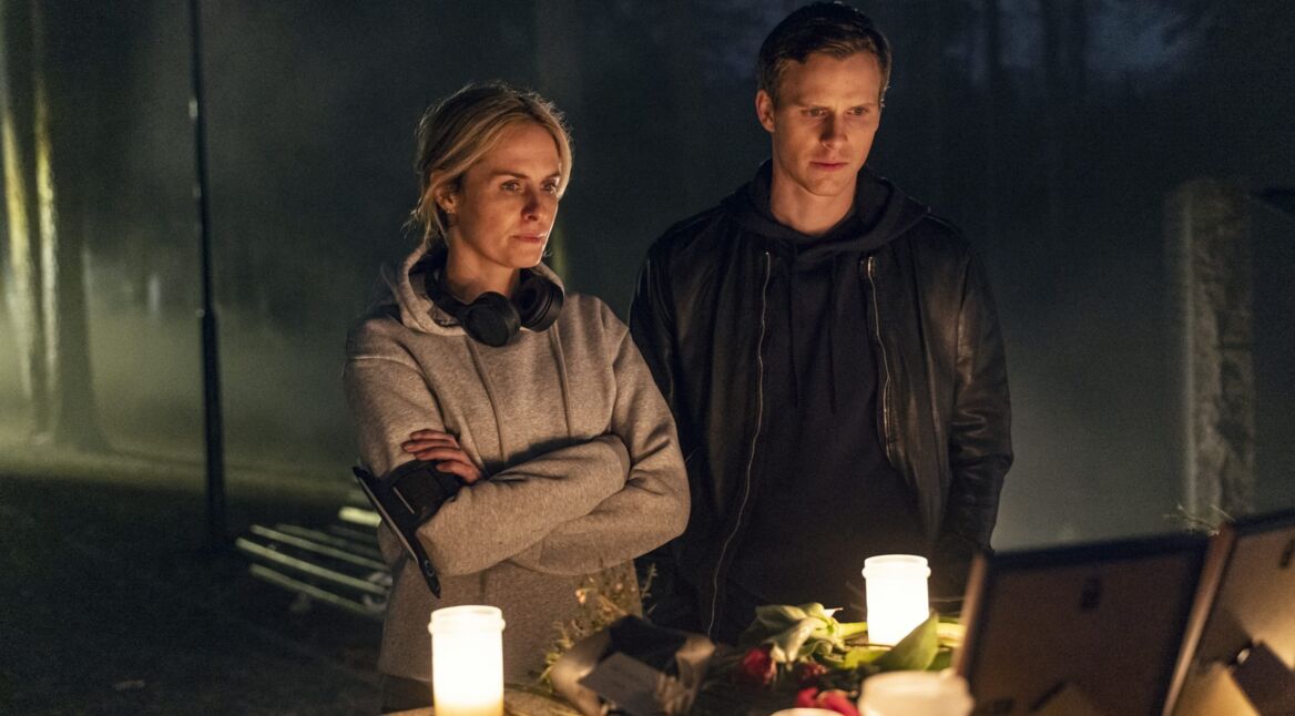 Eine Frau und ein Mann in einem dunklen Raum vor Kerzen