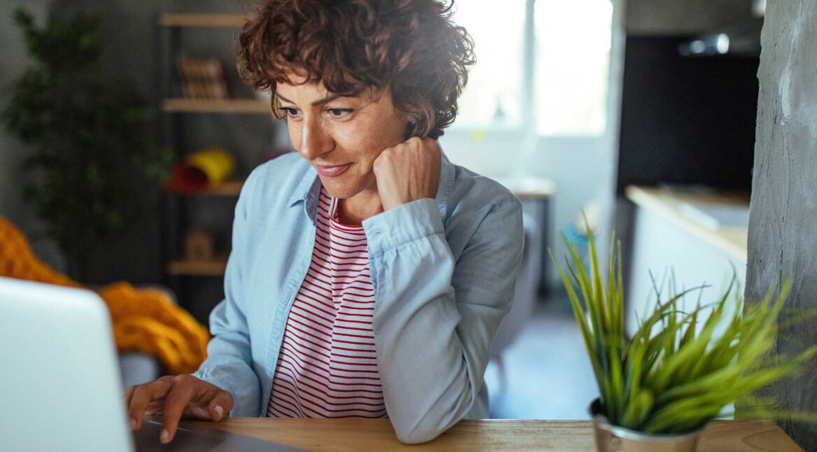 Eine Frau sitzt an ihrem Laptop