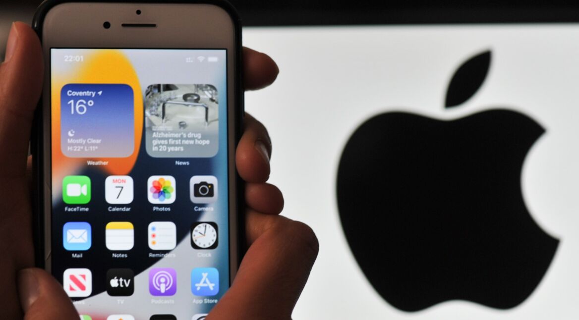 iPhone mit iOS 15 und Apple-Logo im Hintergrund