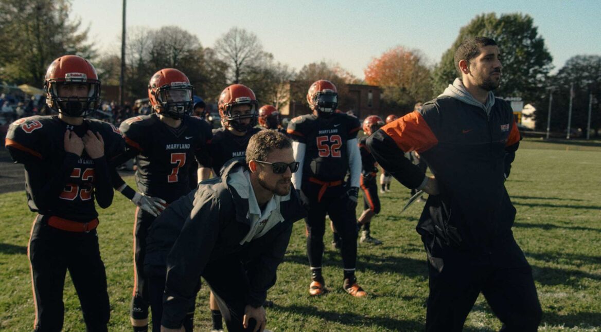 Zwei Trainer am Rand eines Football-Felds bei einem Spiel