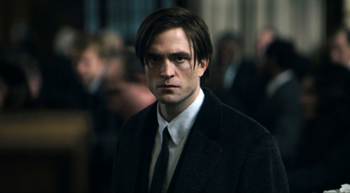 Ein finster blickender Mann in dunkler Kulisse