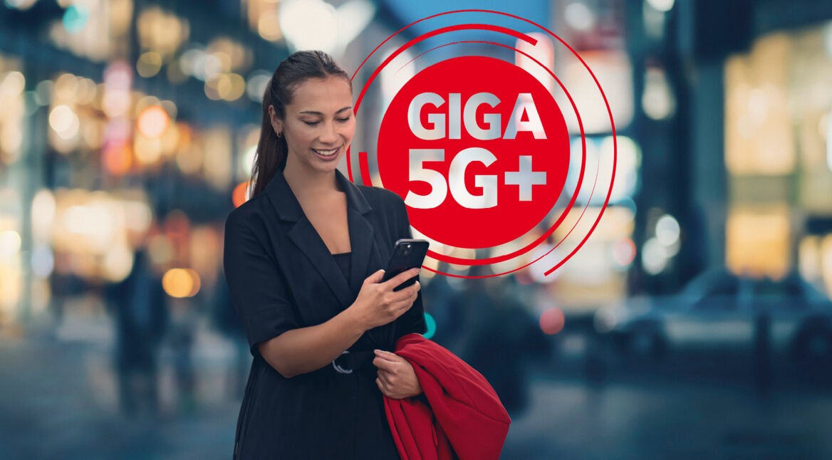 Eine Frau schaut auf ihr Smartphone das blitzschnell mit Giga 5G+ läuft