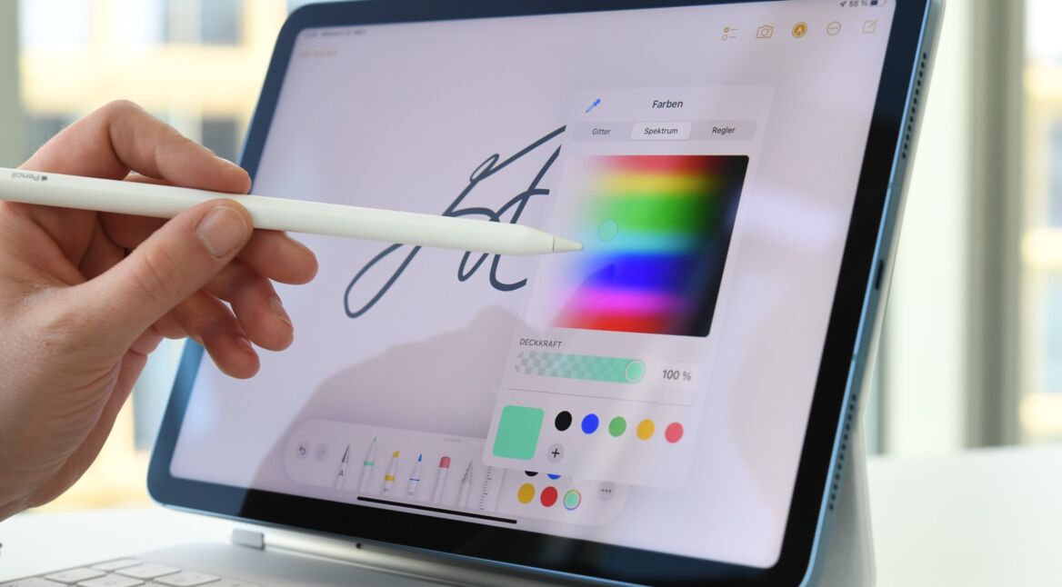 Frauenhand führt Stift auf einem iPad und wählt aus Farbpalette aus