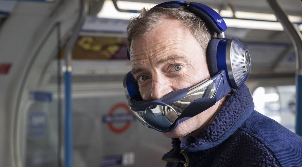 Ein Mann im Bus trägt einen Kopfhörer mit Mundschutz