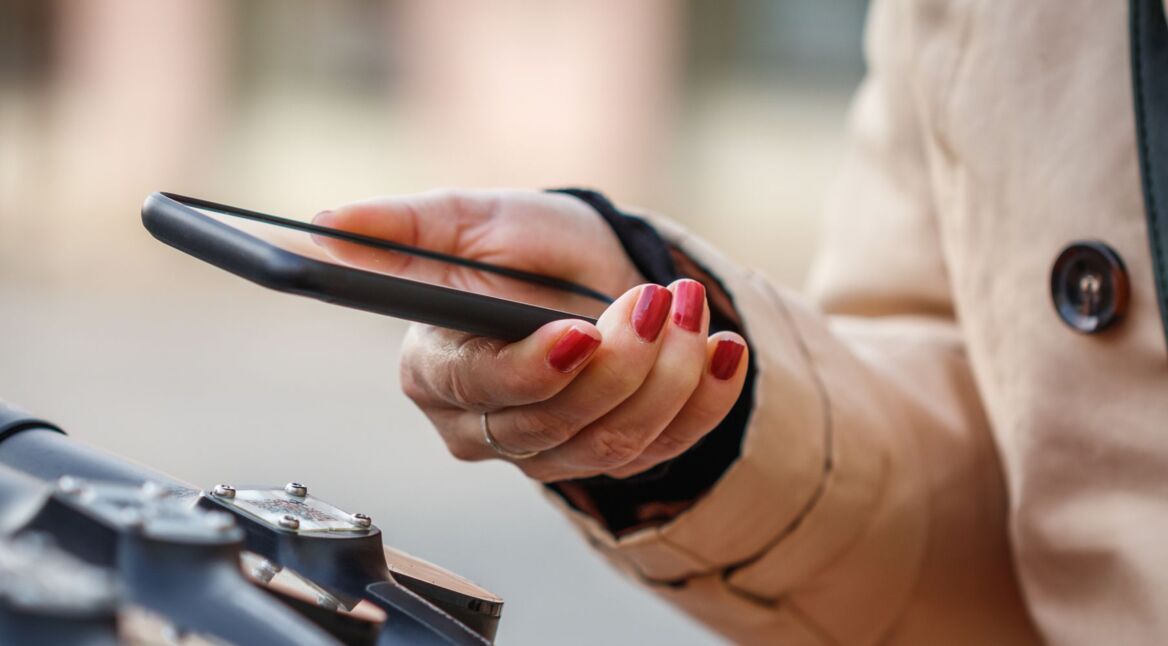 Frau hält iPhone in der Hand.