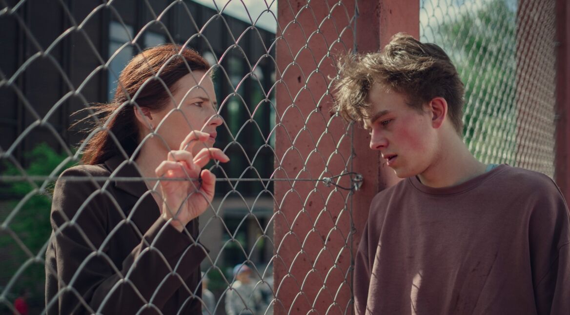 Eine Frau, ein Zaun, ein junger Mann