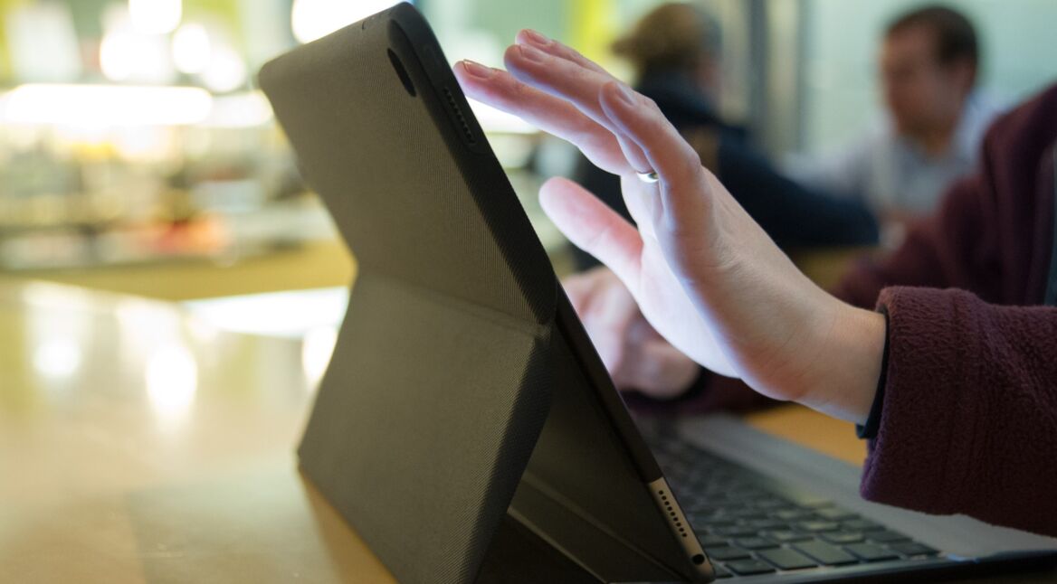 Frauenhände tippen auf iPad mit Tastatur