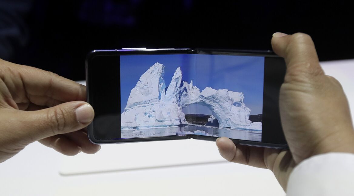 Zwei Hände halten das in der Mitte geklappte Smartphone Galaxy Z Flip