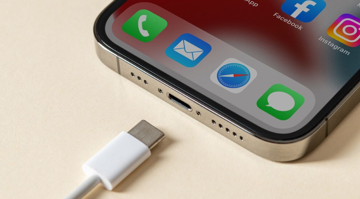 iPhone auf hellem Untergrund mit USB-C-Kabel