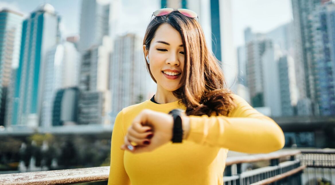 Frau schaut auf ihre Smartwatch.