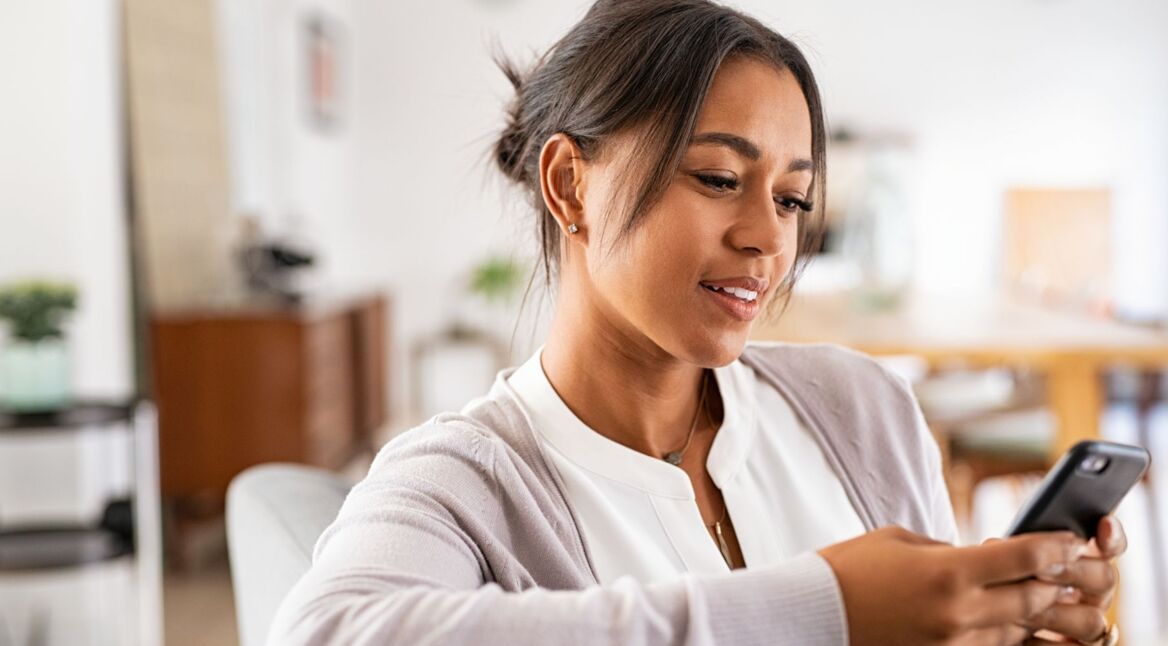 Frau liest WhatsApp-Nachricht auf ihrem Handy.