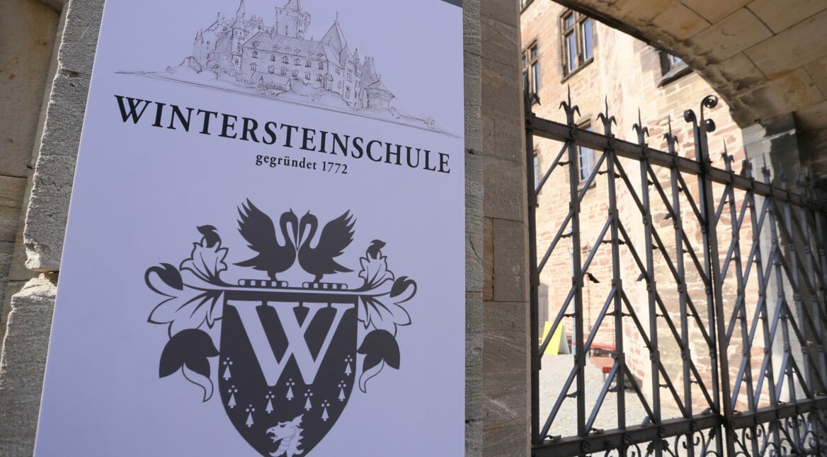 Filmkulisse: Schild an einem Schloss mit der Inschrift "Wintersteinschule"