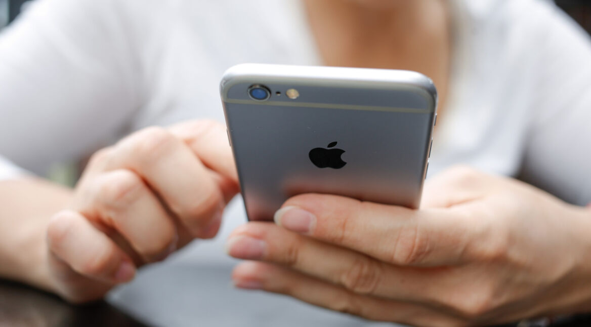 Zwei Hände halten ein iPhone 6s in Großaufnahme