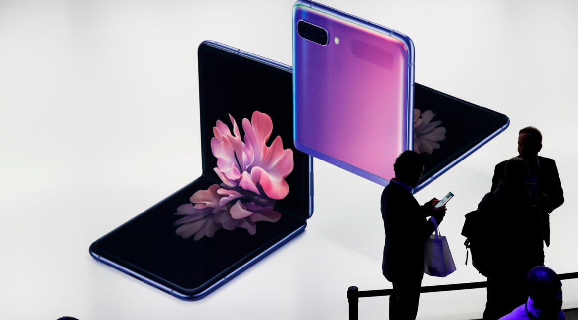 Menschen stehen vor einer Werbung für das Klapphandy Samsung Galaxy Z Flip.