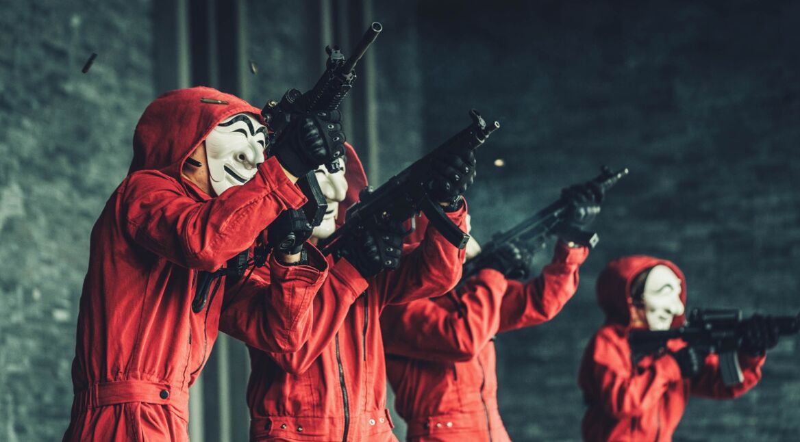 Vier maskierte Bewaffnete in Rot.