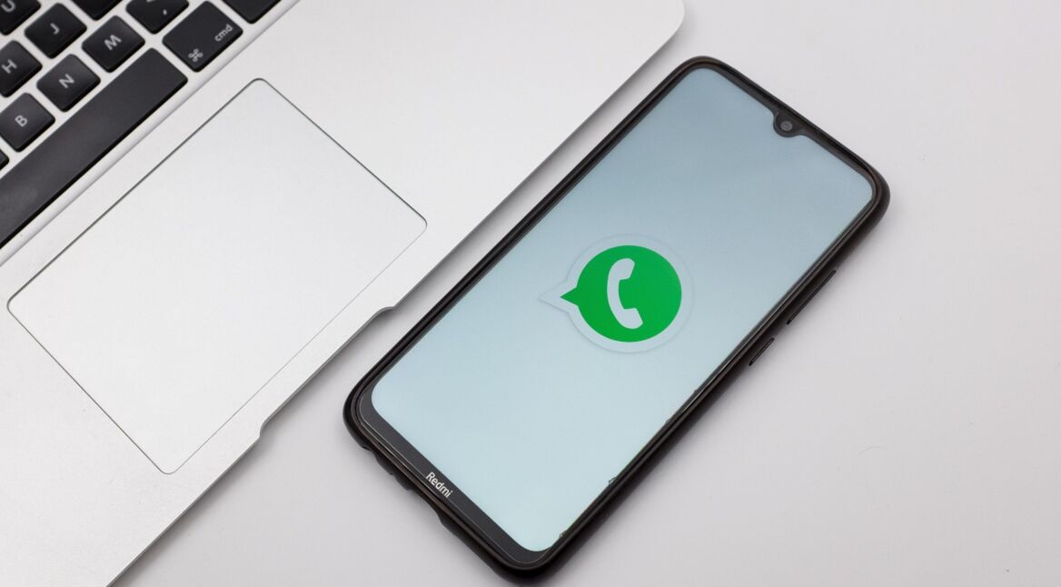 Ein Handy liegt neben einem Notebook.