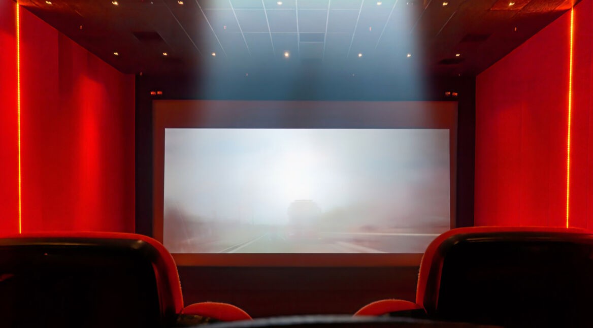 Roter Kinosaal mit Sessel und Leinwand