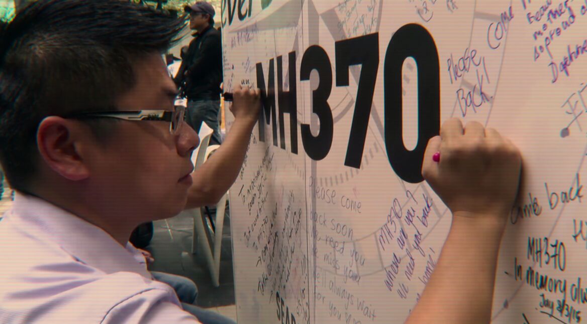 Ein Mann schreibt auf einer Tafel.