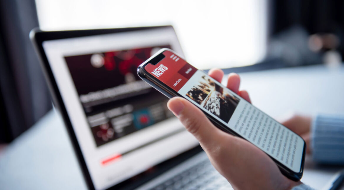 person liest neuigkeiten auf news app