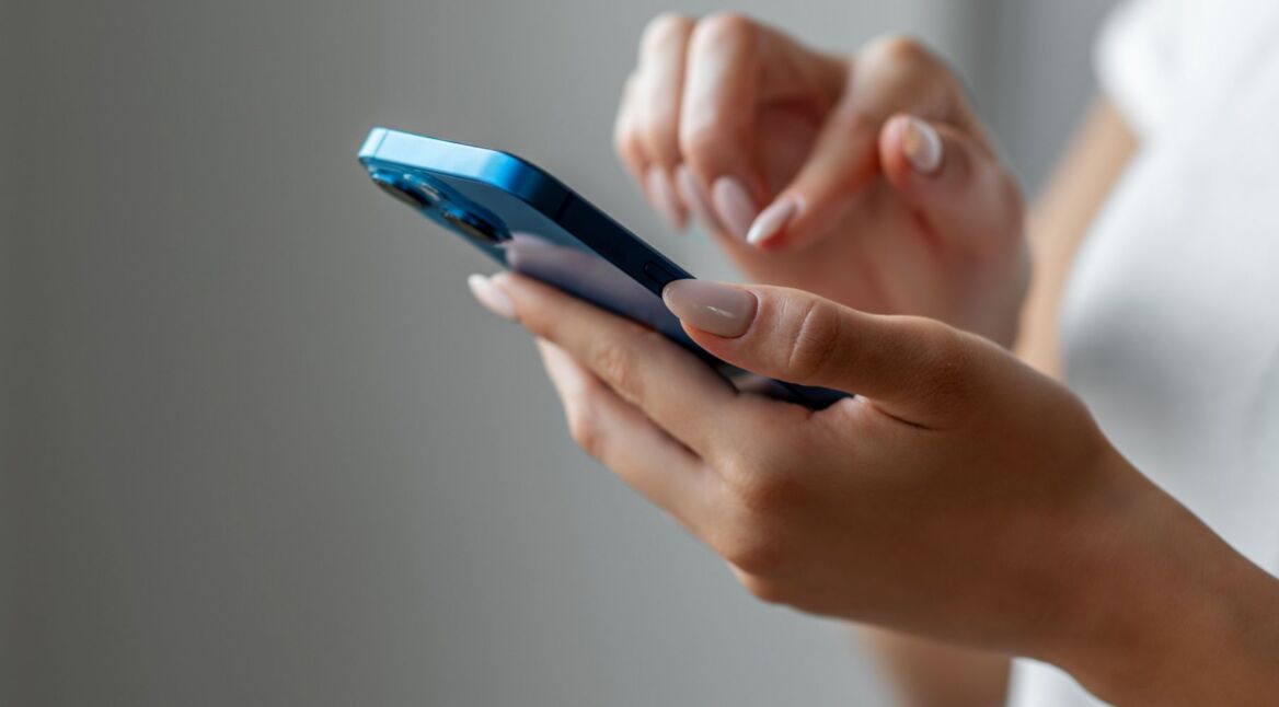 Frau hält iPhone in der Hand