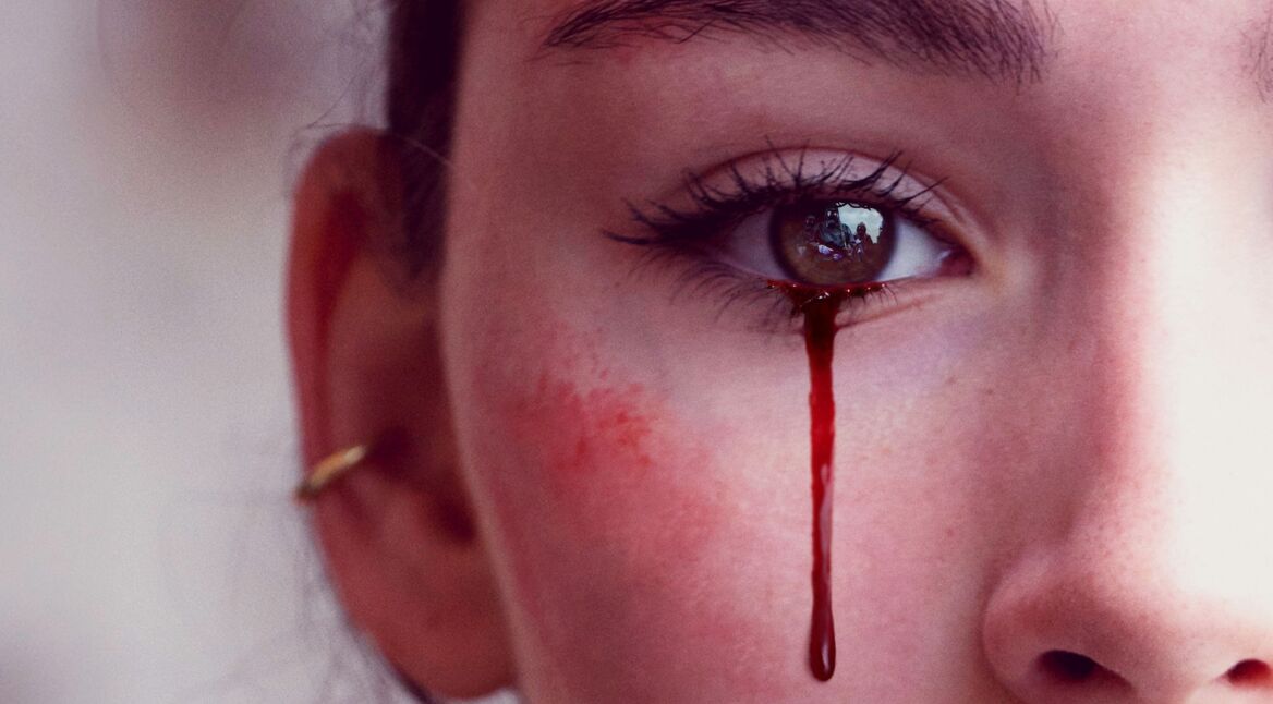 Eine Frau weint blutige Tränen