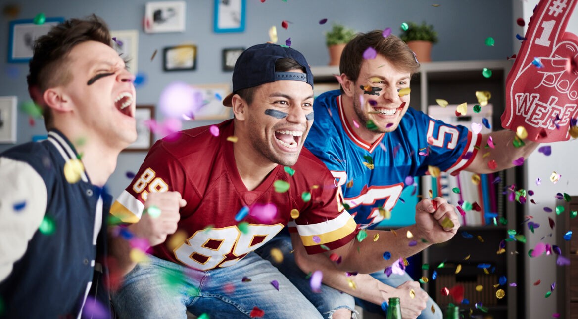 drei Freunde schauen gemeinsam den Super Bowl 57