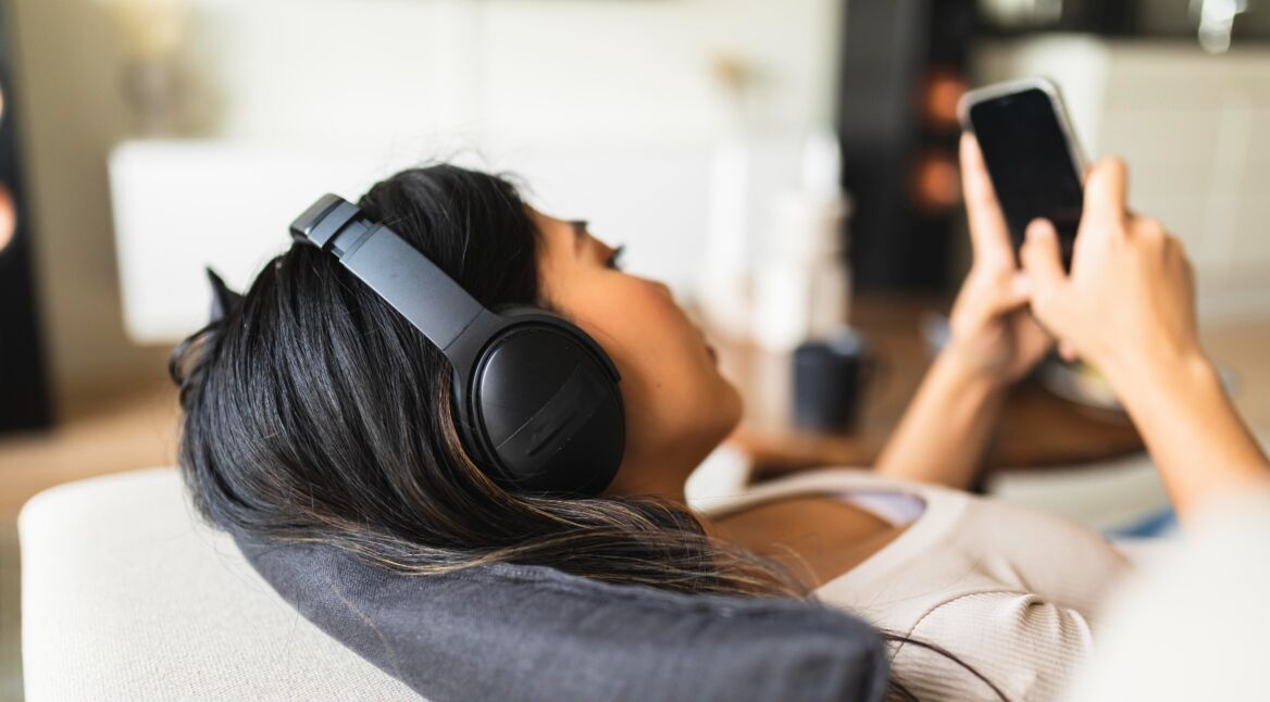 Juinge Frau mit Kopfhörer und Smartphone