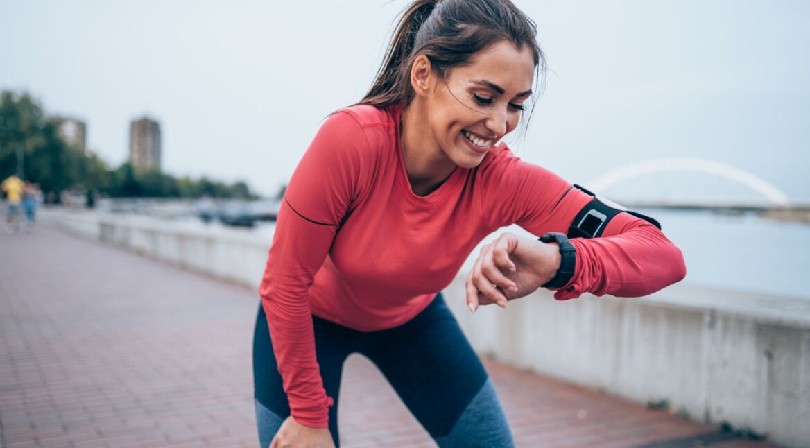 Frau schaut auf ihre Smartwatch beim Sport