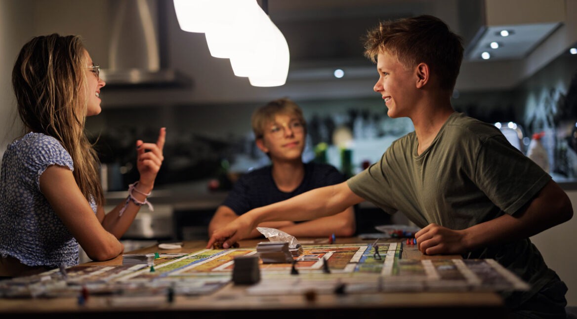 Drei Jugendliche spielen zusammen ein analoges Star Wars Spiel